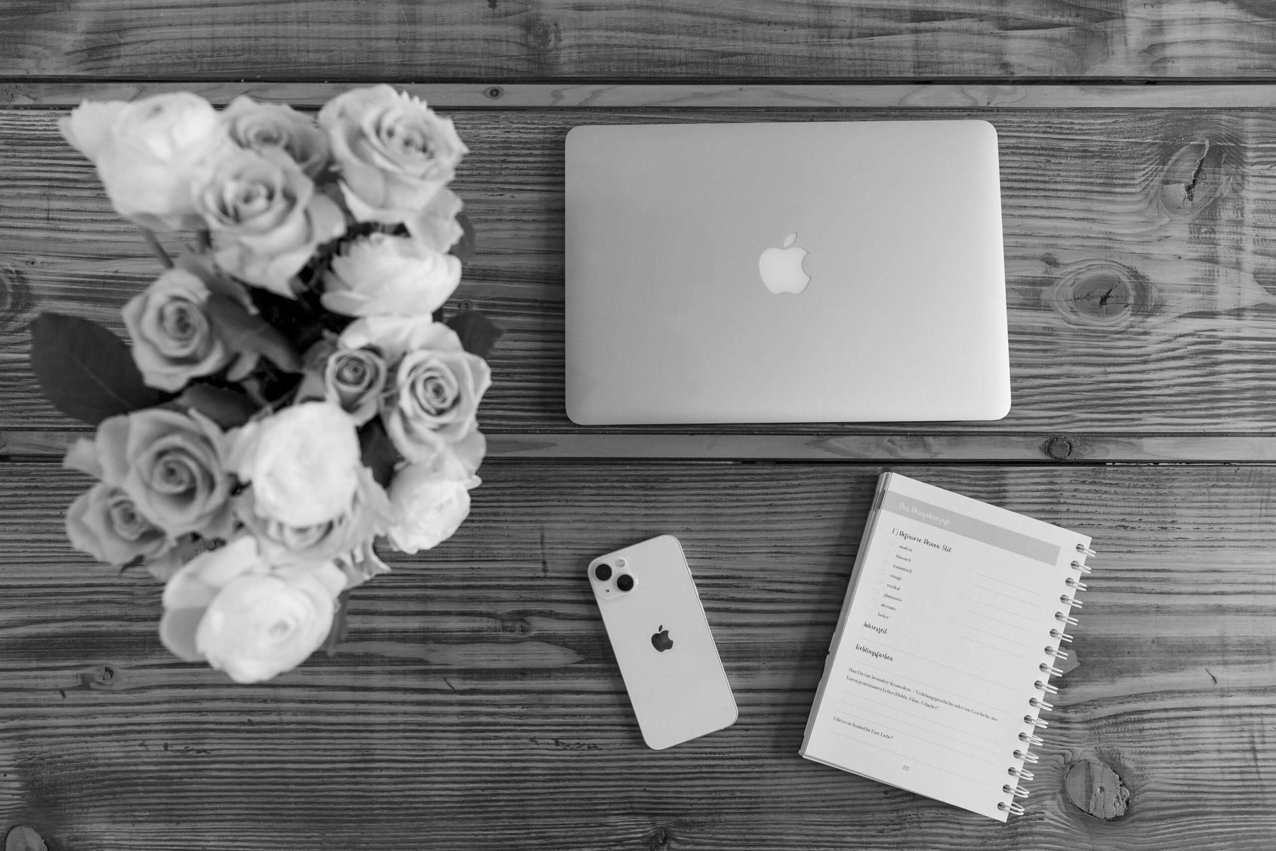 Arbeitsutensilien in schwarz weiß / MacBook und IPhone mit Blumenstrauß